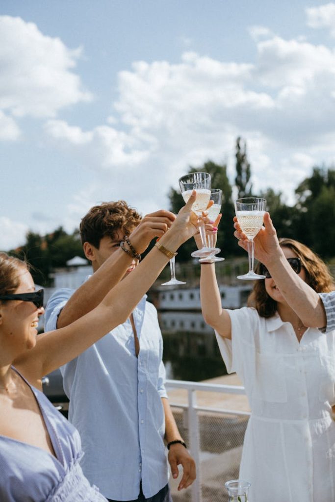 friends-toasting-their-champagne-glasses-9750924 Group of friends celebrating on a yacht with champagne under a sunny sky.