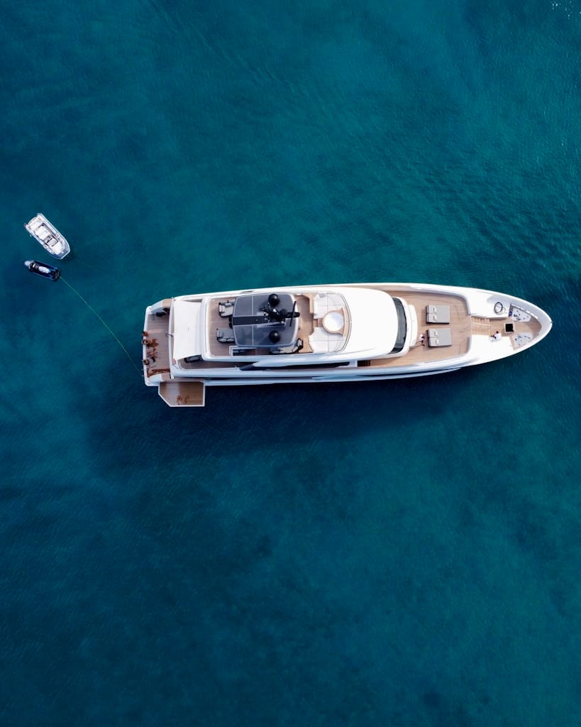 A stunning aerial view of a luxury yacht on the clear waters of Paros, Greece.