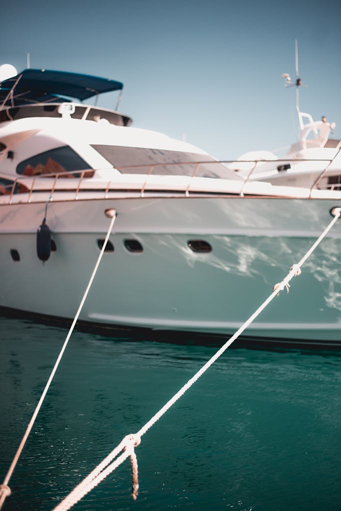 Close-up of a luxury yacht docked at the waterfront with ropes visible.
