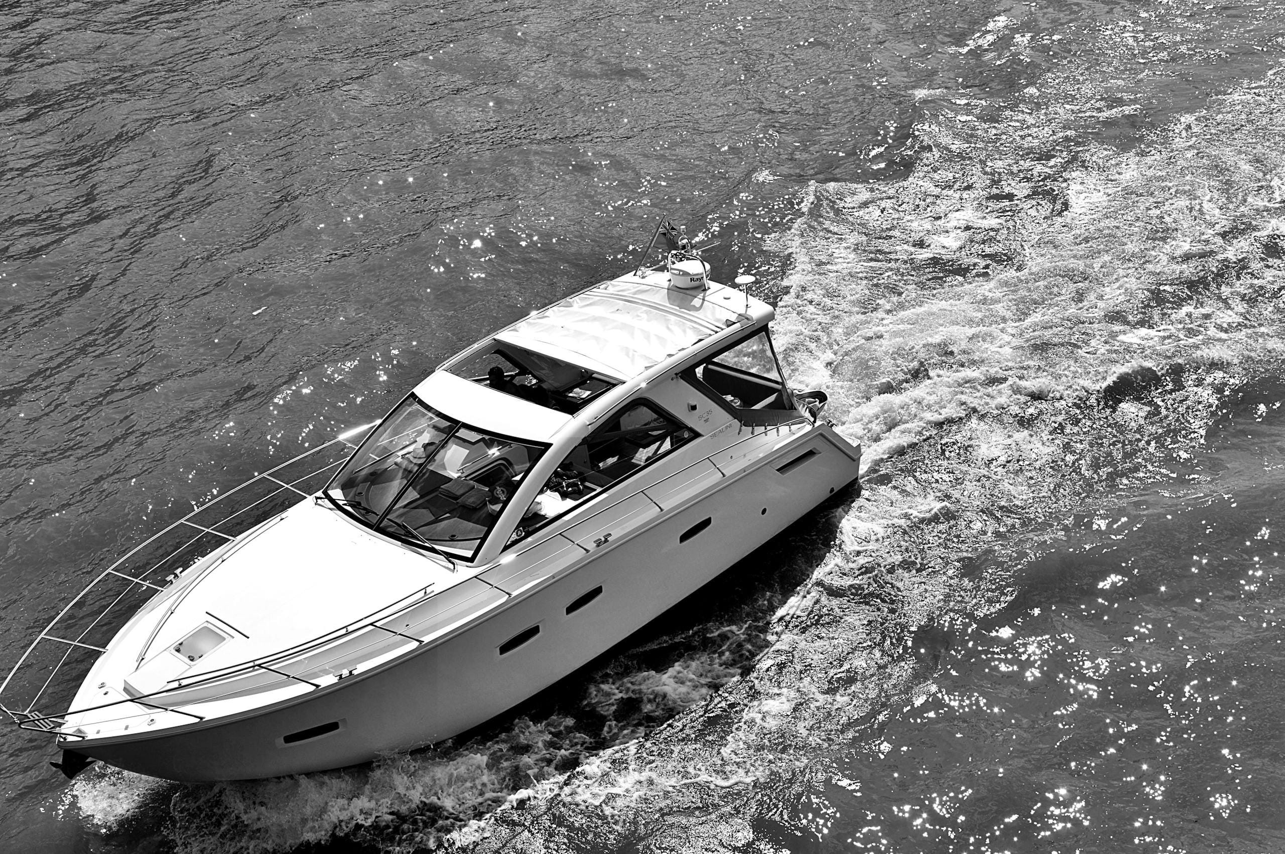 Elegant yacht cruising a river captured in a high contrast black and white photograph.