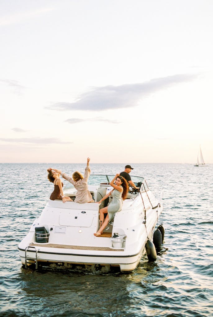 Photo par Vladimir Konoplev Group of adults enjoying a lively boat trip on open water during sunset, capturing the essence of freedom and leisure.