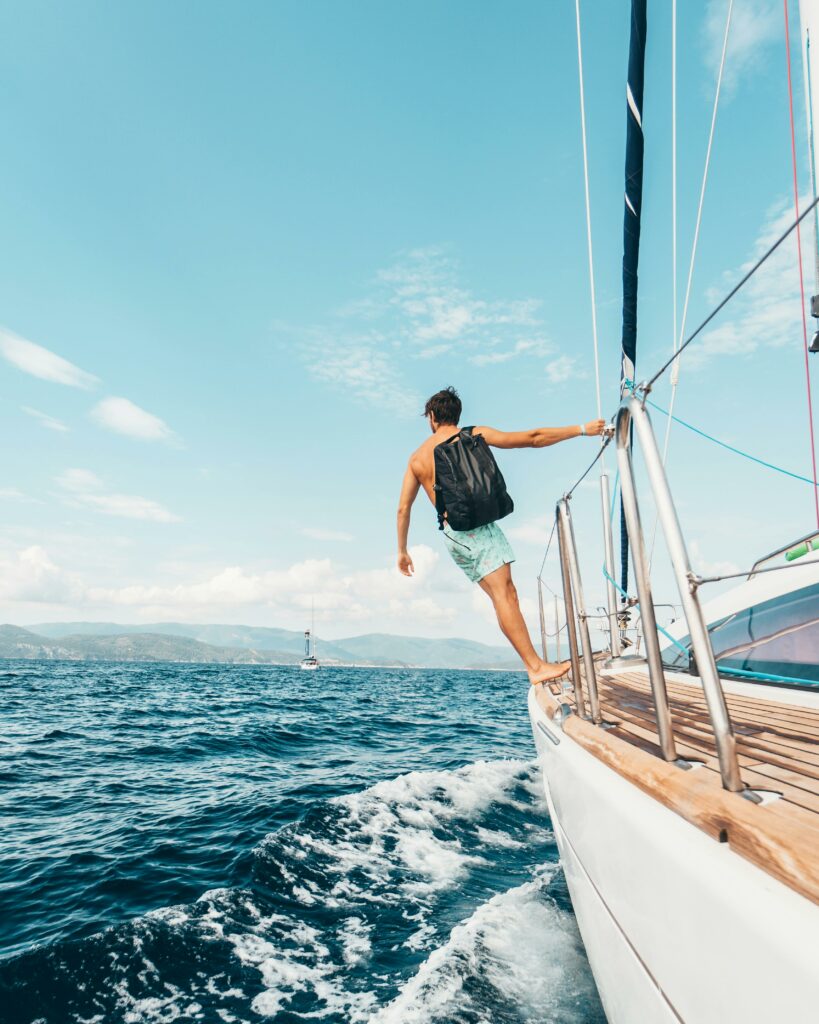 pexels-photo-1223648-1223648 Man sailing in vibrant Greek waters, depicting freedom and adventure under clear skies.