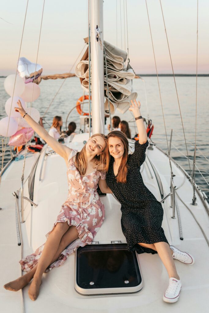pexels-photo-5046521-5046521 Two women enjoying a sunset party on a yacht, celebrating with friends and balloons.