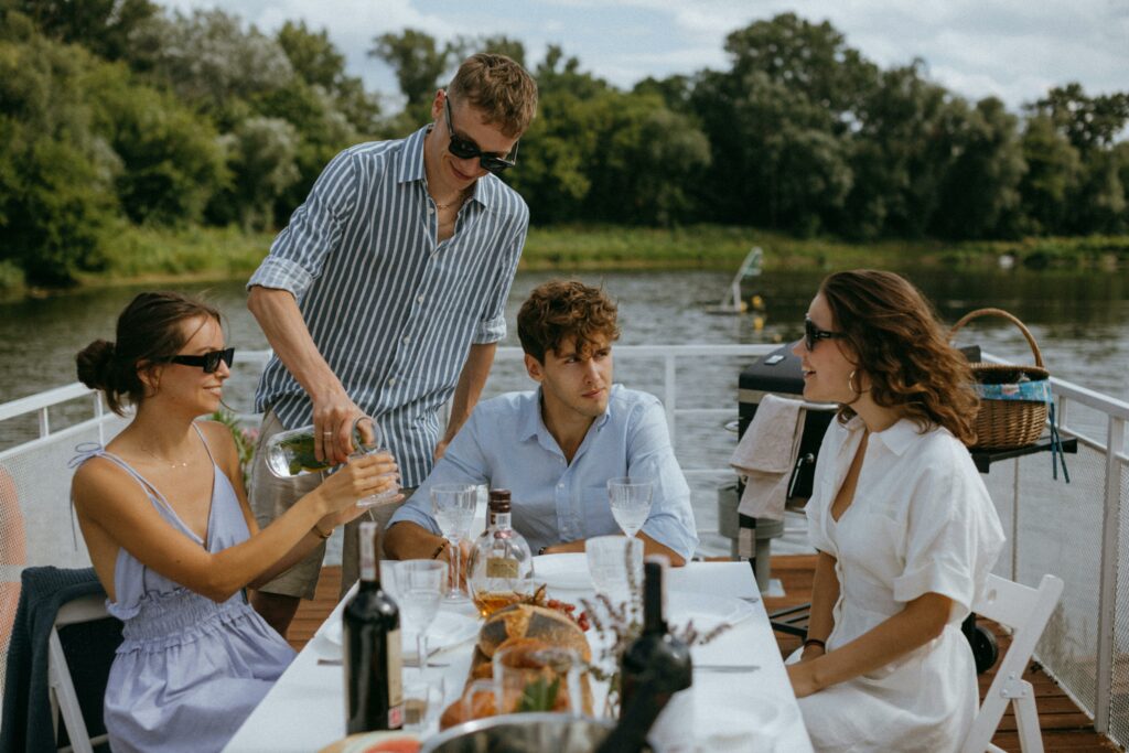 pexels-photo-9750947-9750947 Four friends enjoying a scenic boat dinner party on a sunny day.